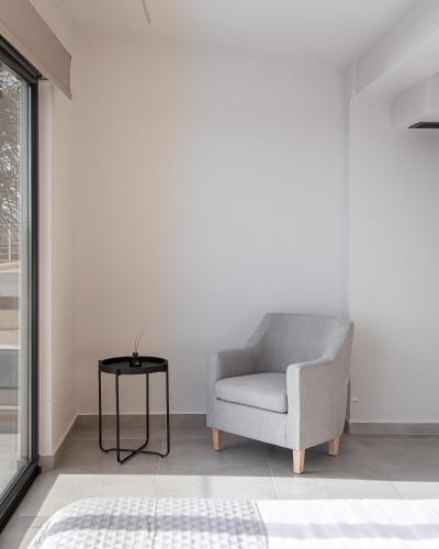 a chair in a living room with a table at Saronida Hills in Saronida