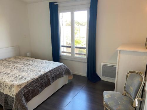 une chambre avec un lit, une fenêtre et une chaise dans l'établissement Maison a 5 min des plages, à Six-Fours-les-Plages