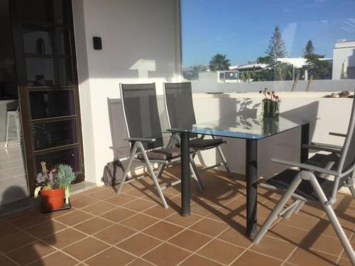 a table and chairs on a balcony with a view at Natural y sano: Charco del Palo in Charco del Palo