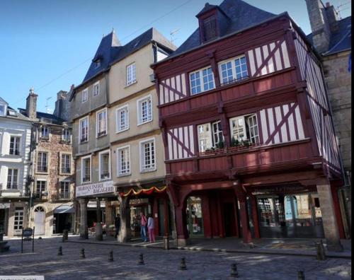 un edificio rosso e bianco su una strada cittadina di EGLANTINE 14 APPARTEMENT CENTRE HISTORIQUE DE DINAN a Dinan