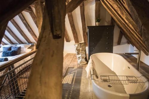 a large white bath tub in a attic at West Street Loft in Midhurst