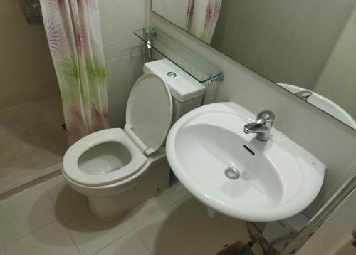 a bathroom with a toilet and a sink at Room at SM Bicutan with Balcony in Manila