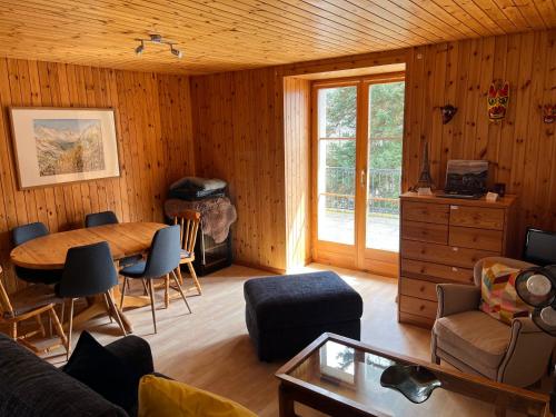 a living room with a table and a couch at Au village d'Evolène, bel appartement avec terrasse in Evolène