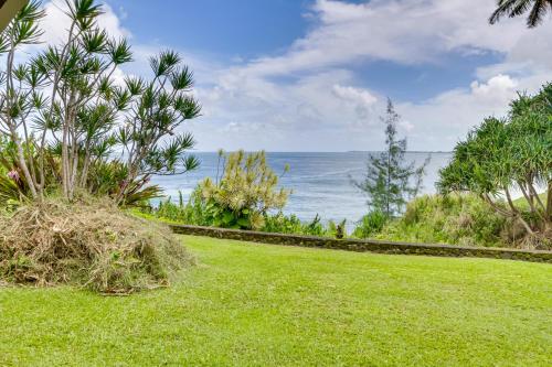 a lawn with a view of the ocean at Hilo Home with Private Deck and Stunning Ocean Views! in Hilo
