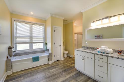 a bathroom with a tub and a sink and a window at Pet-Friendly Emerald Isle Vacation Rental! in Emerald Isle