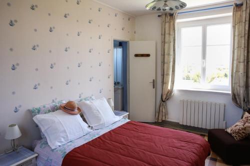 - une chambre avec un lit rouge et une fenêtre dans l'établissement CRASVILLE- EN COTENTIN VUE EPOUSTOUFLANTE SUR LA MER, à Crasville