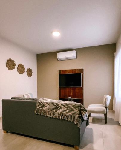 a bedroom with a bed and a flat screen tv at El Colonial Departamentos in Cafayate