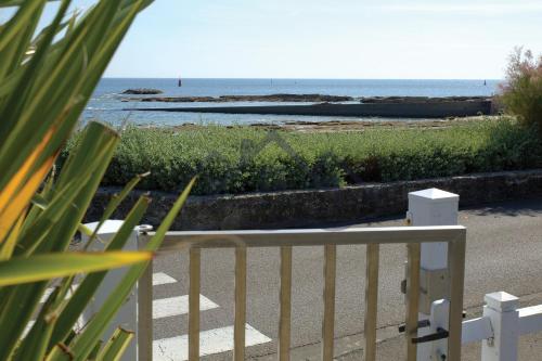 een wit hek met uitzicht op de oceaan bij LocaLise - Maison E2 au Guilvinec - A 20m de la mer avec jardin et piscine - Tout à pied, plage, port, centre commerces, marché - Wifi inclus - Vue mer de la chambre - Animaux bienvenus - Linge de lit inclus in Le Guilvinec