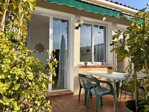 a patio with a table and chairs and a window at Hotel & Appartements Punta e Mare in Cargèse