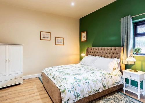 a bedroom with a green wall and a bed at Beech Tree Lakes Lodges in Hatfield