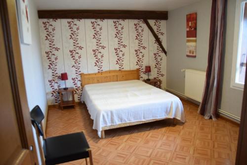 a bedroom with a white bed in a room at Sente des Vignes in Hauteville