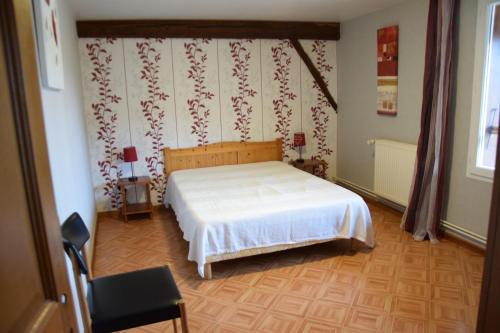 1 dormitorio con 1 cama blanca en una habitación en Sente des Vignes, en Hauteville