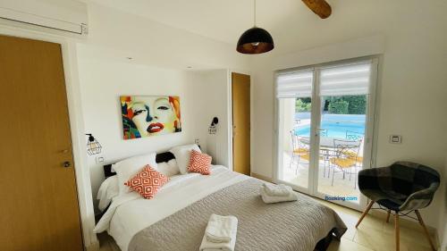 a bedroom with a bed and a view of a pool at Les Chenes in Sainte-Maxime