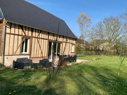 duży drewniany dom z trawnikiem przed nim w obiekcie Gîte, Maison entière avec billard et bel espace de vie La Grange w mieście Blicourt