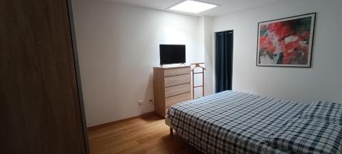 a bedroom with a bed and a tv on a dresser at Sa Domo de Paolo in Alghero