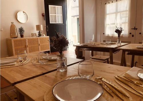 - une salle à manger avec une table en bois et des verres dans l'établissement MAISON HÔTEL SES PENYES, à Alaior