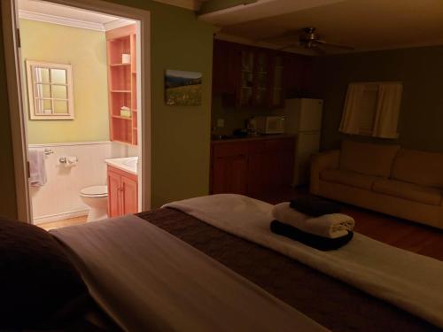 a bedroom with a bed and a bathroom at Riverbend Guest House in Chilliwack