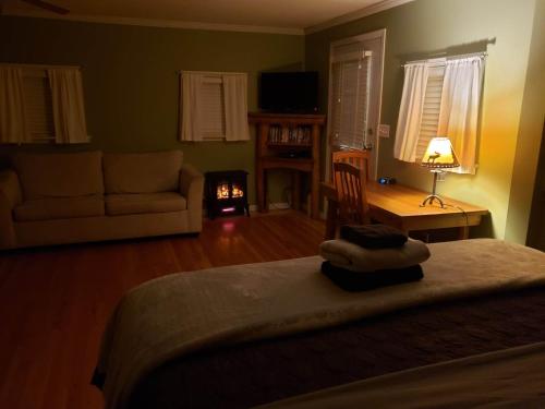 a bedroom with a bed and a living room with a couch at Riverbend Guest House in Chilliwack