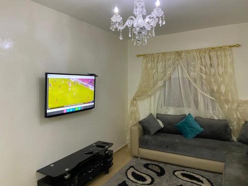 sala de estar con sofá y TV de pantalla plana en Casablanca Airport Appartement en Deroua