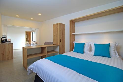 a bedroom with a large bed with blue pillows at APART HOTEL CASA BLANCA in Cuenca