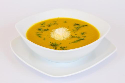 a white bowl of soup with cheese and herbs at Hotel Casa de la Vega in Bogotá