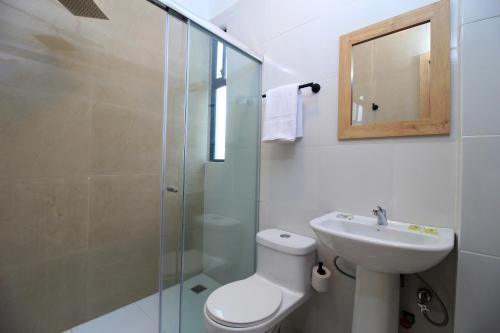 a bathroom with a toilet and a sink and a shower at Apart Hotel Casa Blanca in Cuenca