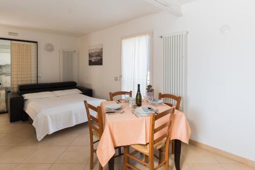 uma sala de jantar com uma mesa e uma cama em Appartamenti Ceccherini em Malcesine