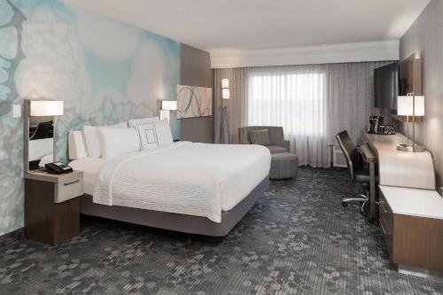 a hotel room with a bed and a desk at Courtyard by Marriott Toronto Vaughan in Vaughan