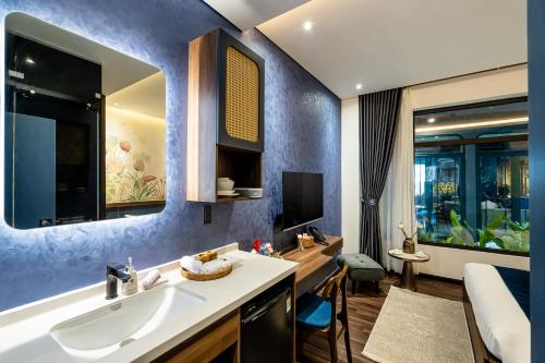 a bathroom with a sink and a bedroom at KunKin Garden Aparthotel in Ho Chi Minh City