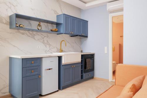 una cocina con armarios azules y fregadero en Old Town Hall Apartment en Corfú