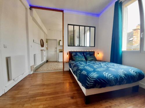 - une chambre avec un lit et une grande fenêtre dans l'établissement Le Cocon, à Rennes
