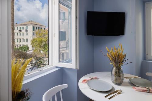 uma sala de jantar com uma mesa branca e uma janela em Old Town Hall Apartment em Corfu Town