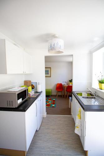 a kitchen with a sink and a microwave at Krissie's in Marazion