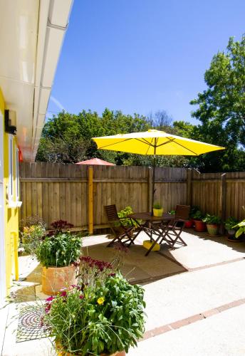 a patio with a table and a yellow umbrella at Krissie's in Marazion