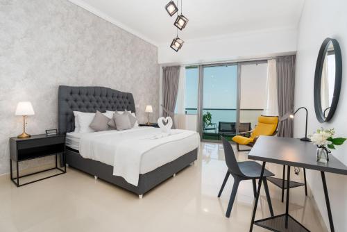 a bedroom with a bed and a table and a desk at White Sage - Incredible Full Sea and Dubai Eye View in Marina in Dubai