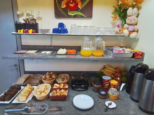 a counter with a bunch of different types of food at Hospedaria Gengibre in Barra Velha