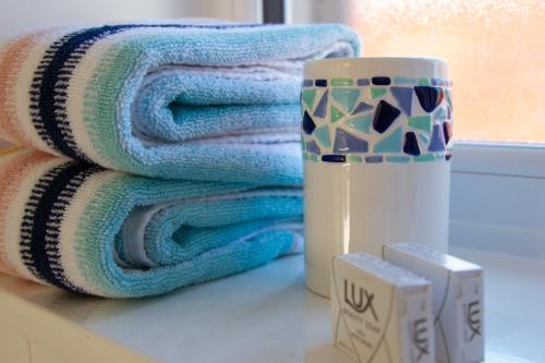 a stack of towels sitting next to a mug at Krissie's in Marazion