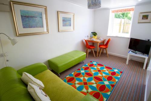 a living room with a green couch and a table at Krissie's in Marazion