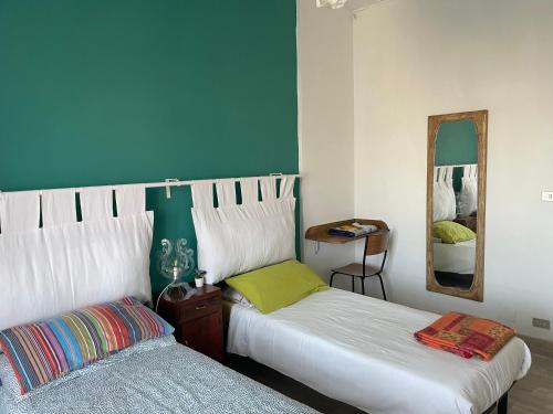 a bedroom with two beds and a mirror at Appartamento luminoso in Ciriè