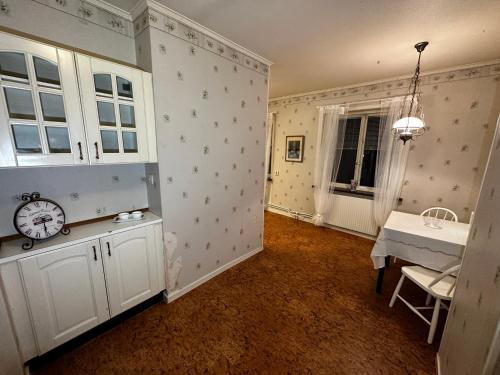 Zimmer mit einem Tisch und einer Uhr an der Wand in der Unterkunft Ljungaverk Stor Lägenhet Med Öppen Spis in Ljungaverk