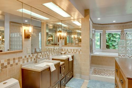 a bathroom with two sinks and a large mirror at Hilo Home with Private Deck and Stunning Ocean Views! in Hilo