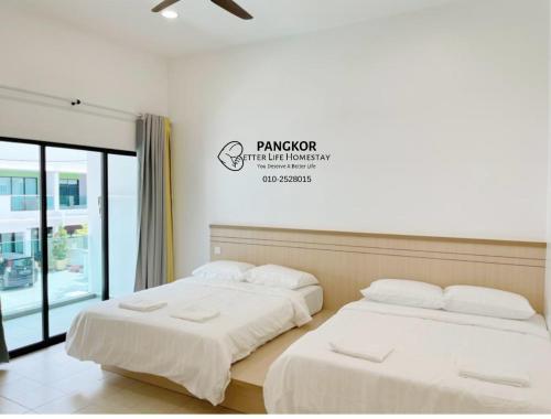 dwa łóżka siedzące obok siebie w pokoju w obiekcie Pangkor Villa88 Double Storey 3min to Pasir Bogak Beach w mieście Pangkor