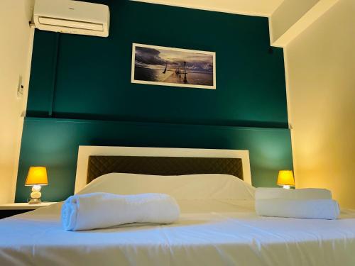 a bedroom with a green wall and a bed with two pillows at Case Eoliane, Alicudi in Patti
