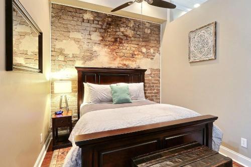 - une chambre avec un lit et un mur en briques dans l'établissement Broughton Hideaway, à Savannah