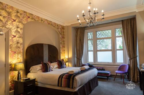 a bedroom with a bed and a chandelier at Burlington House Boutique in Oxford