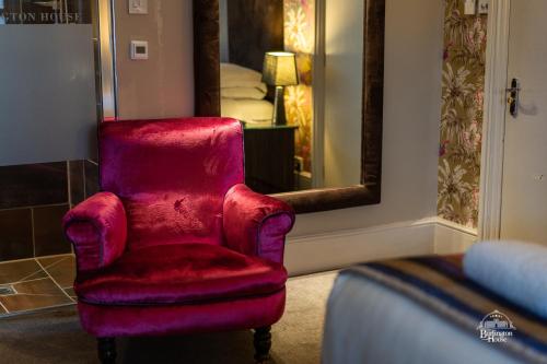 a red chair in a room with a mirror at Burlington House Boutique in Oxford