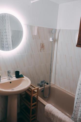 une salle de bain avec un lavabo et une baignoire dans l'établissement Maison climatisatée 2 chambres extérieur barbecue parking gratuit 600m mer, à Saint Cyprien Plage
