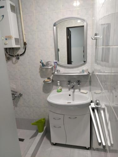 a white bathroom with a sink and a mirror at AA21 in Yerevan