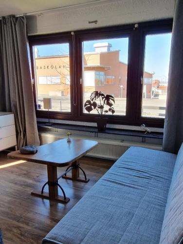 a bedroom with a bed and a table in front of a window at Lägenhet Yvonne in Gränna
