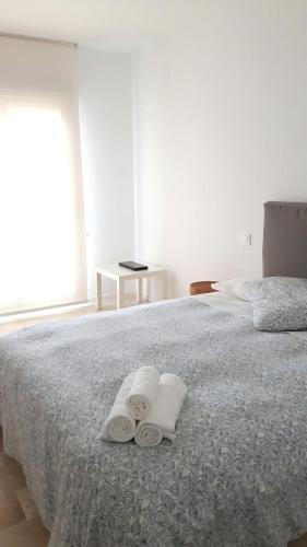 a bedroom with a bed with two towels on it at APARTAMENTO TURÍSTICO CARBONERAS in Carboneras
